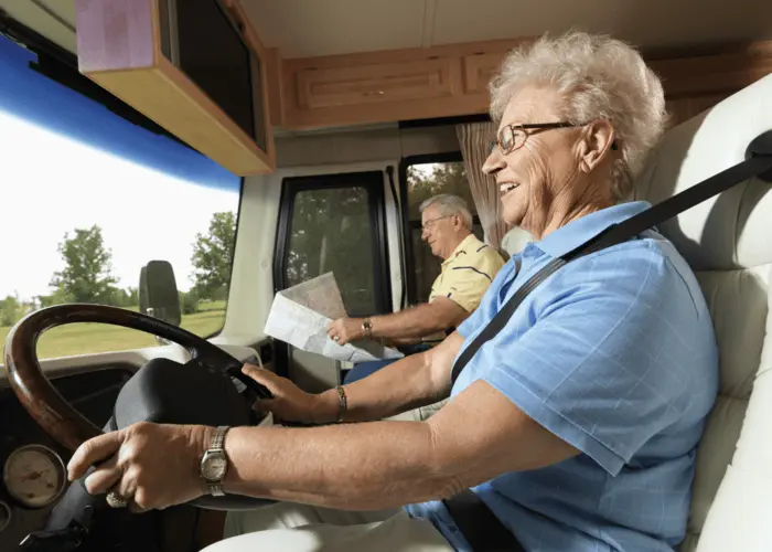 elderly couple driving rv