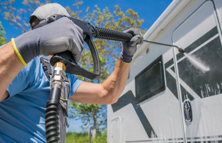 man power washing outside of rv